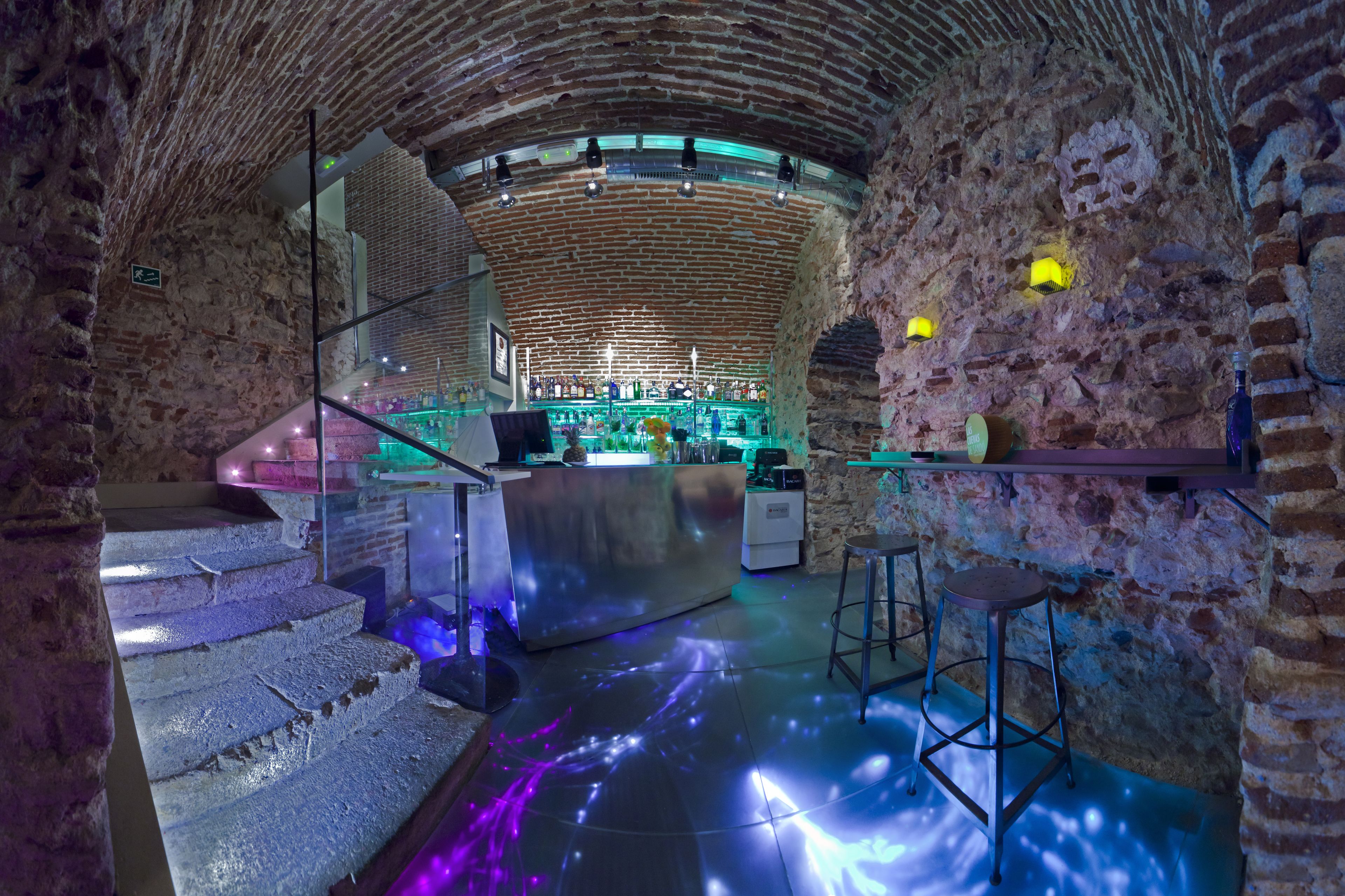 An interior with a brick wall, a bar area, and a staircase.