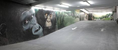 Egy parkolóház, melynek falán gorillákat ábrázoló falfestmény látható.