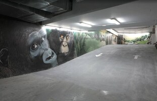 Eine Parkgarage mit einem Wandgemälde von Gorillas.