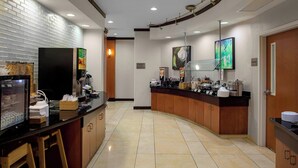 A modern kitchen with a curved counter, stainless steel appliances, and a tiled floor. - Fairfield Inn & Suites by Marriott Montgomery EastChase Pkwy (Montgomery)