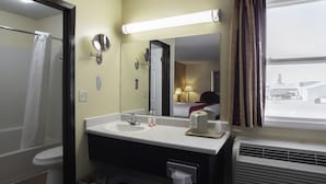A hotel bathroom with a sink, mirror, and toilet. - Nendels Inn & Suites (Dodge City)