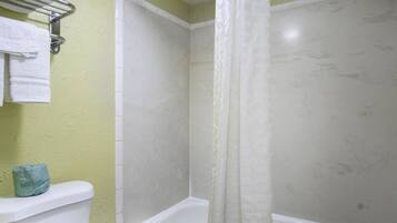 A bathroom with a toilet, a bathtub, and a shower curtain.