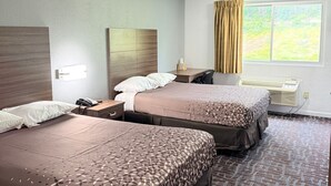 A hotel room with two beds, a desk, a chair, a telephone, and a window with curtains. - Regency Inn And Suites Nashville (Nashville)