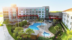 A hotel with a swimming pool, outdoor seating, and a restaurant. - Choctaw Casino & Resort Grant, Trademark Collection by Wyndham (Grant)