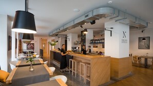 Un restaurante moderno con barra, mesas de madera y taburetes.