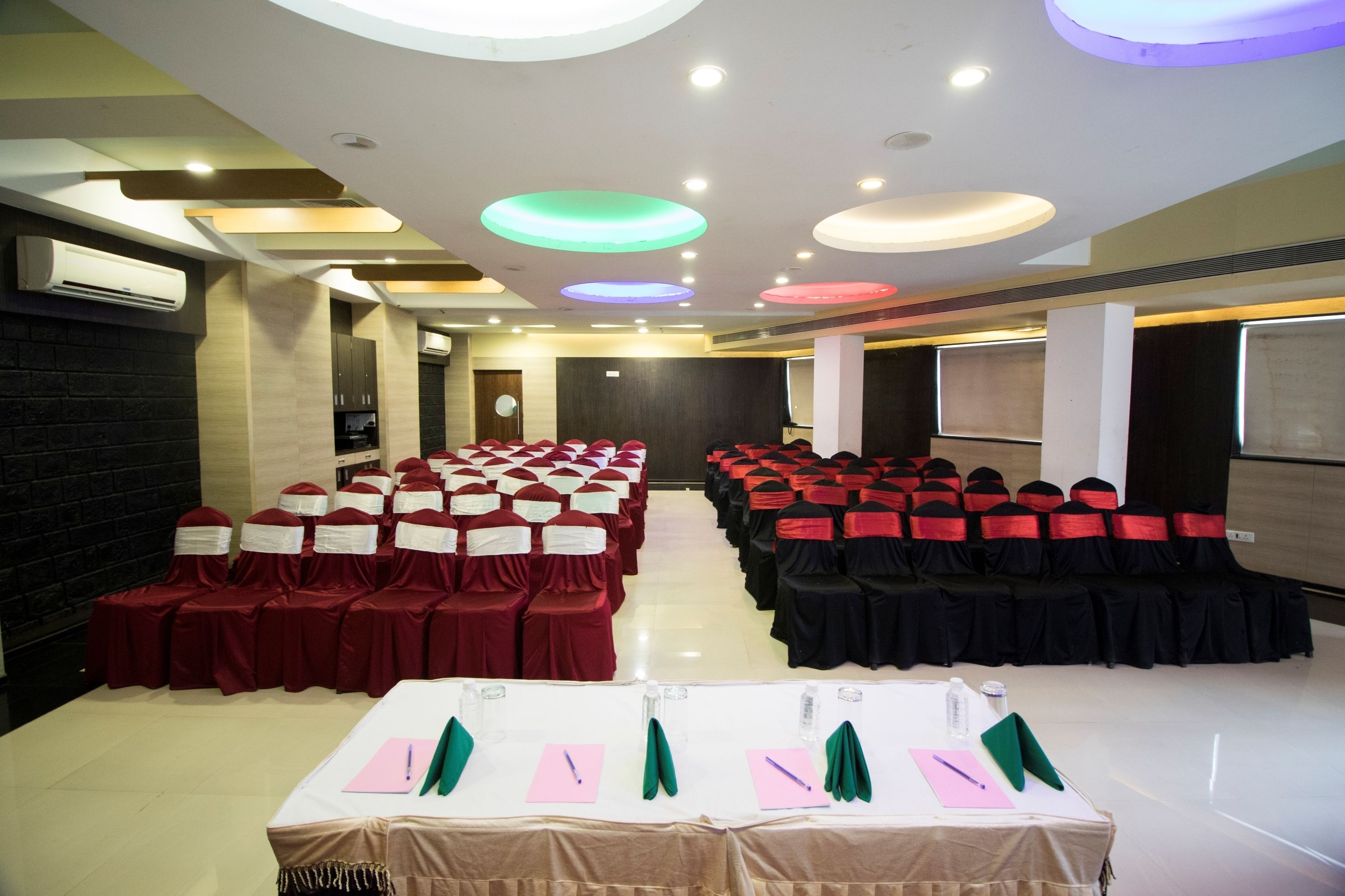 A conference room with rows of chairs, tables with name cards, and a projector screen.