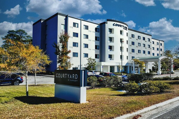 Un hotel Courtyard by Marriott con un diseño moderno, varios pisos y un área de estacionamiento.