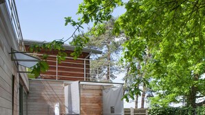 Een houten hut met een hottub, buitenzitplaatsen en een overdekt terras.