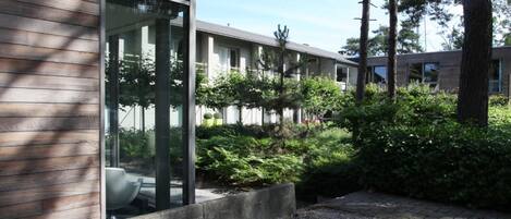 A modern building with large windows and a gravel courtyard.