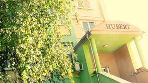 Un edificio con fachada verde y un letrero que dice "HUBERT".