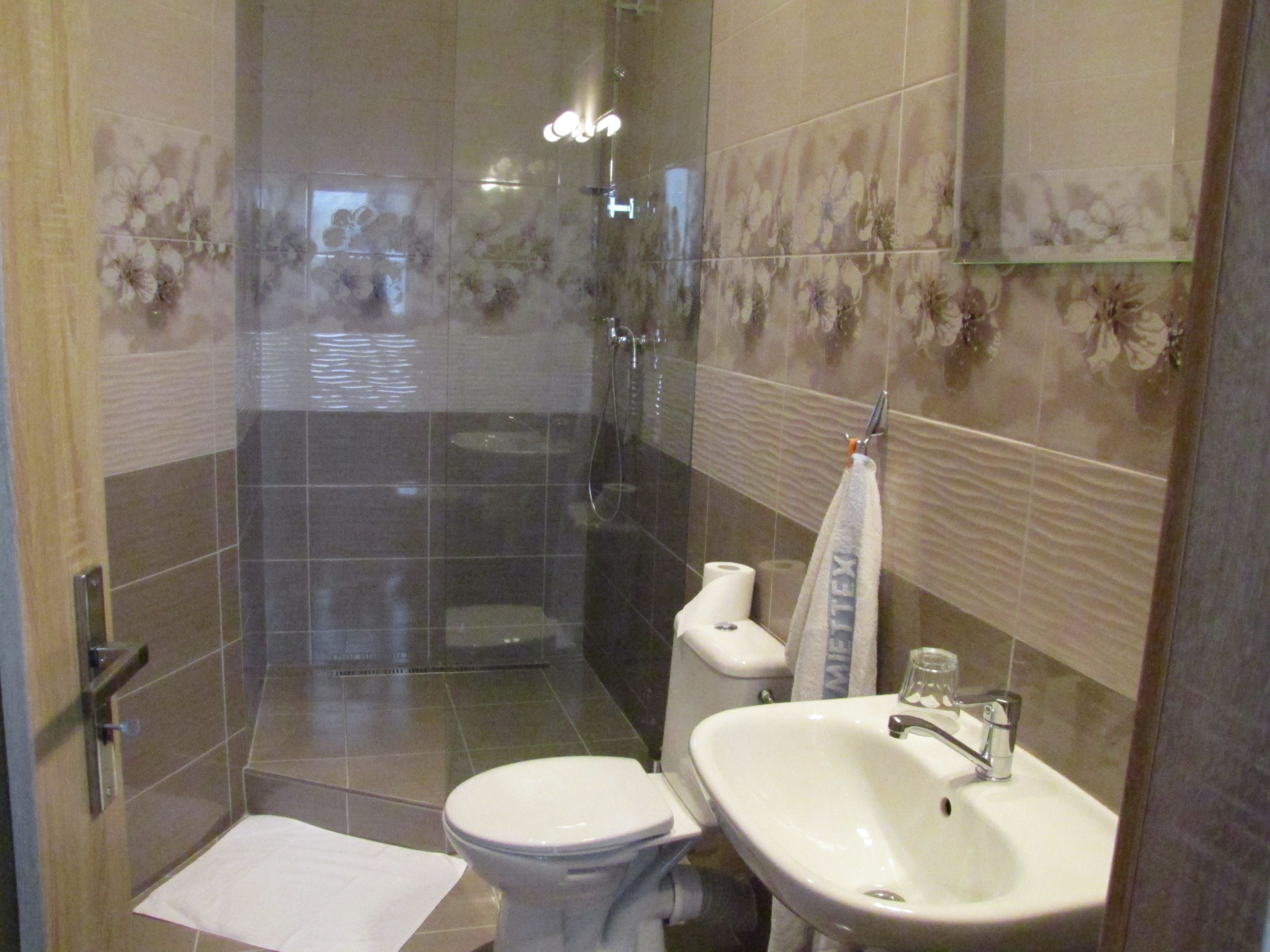 A bathroom with a shower, toilet, and sink.