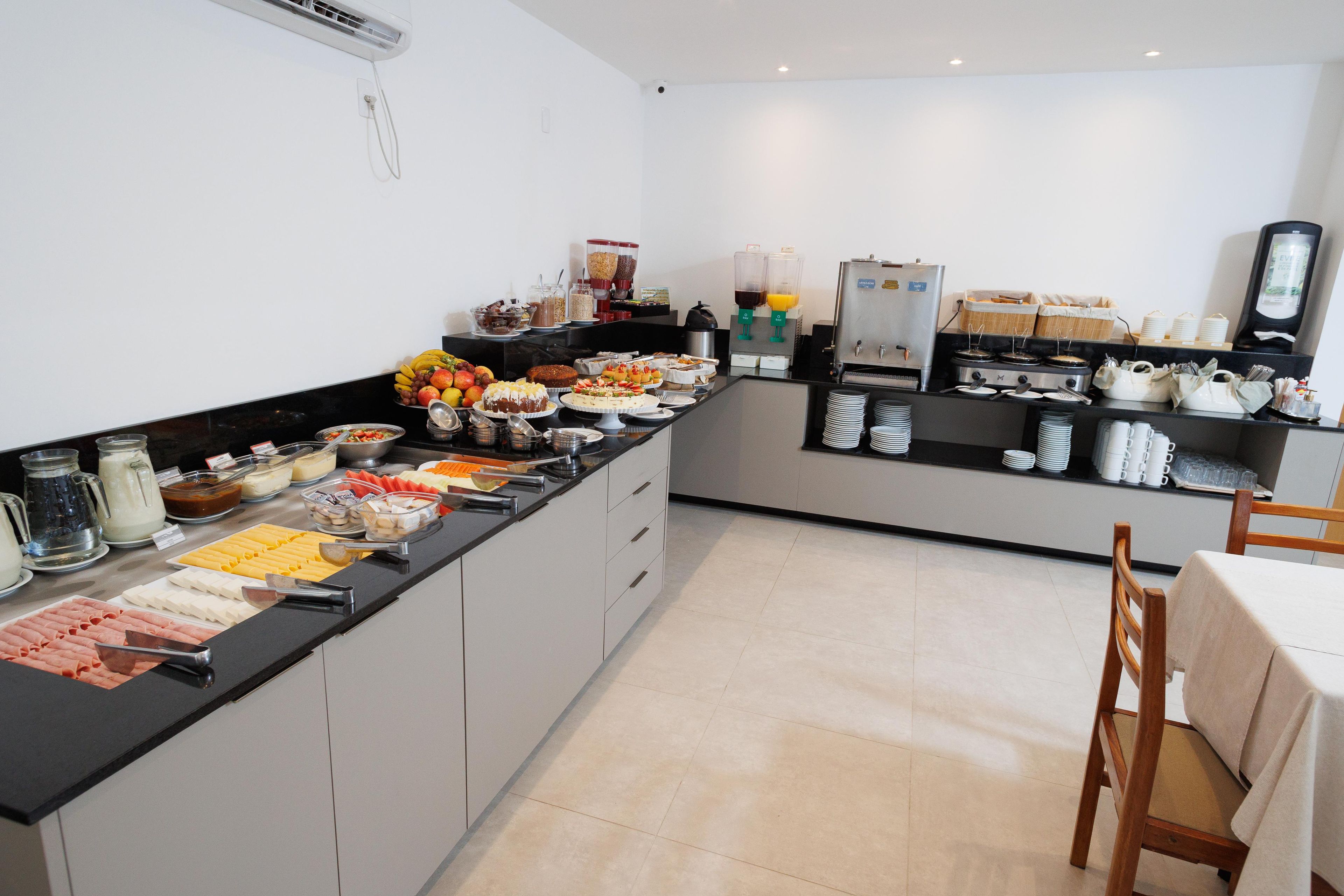 Disposição de buffet com diversos alimentos e uma máquina de café.