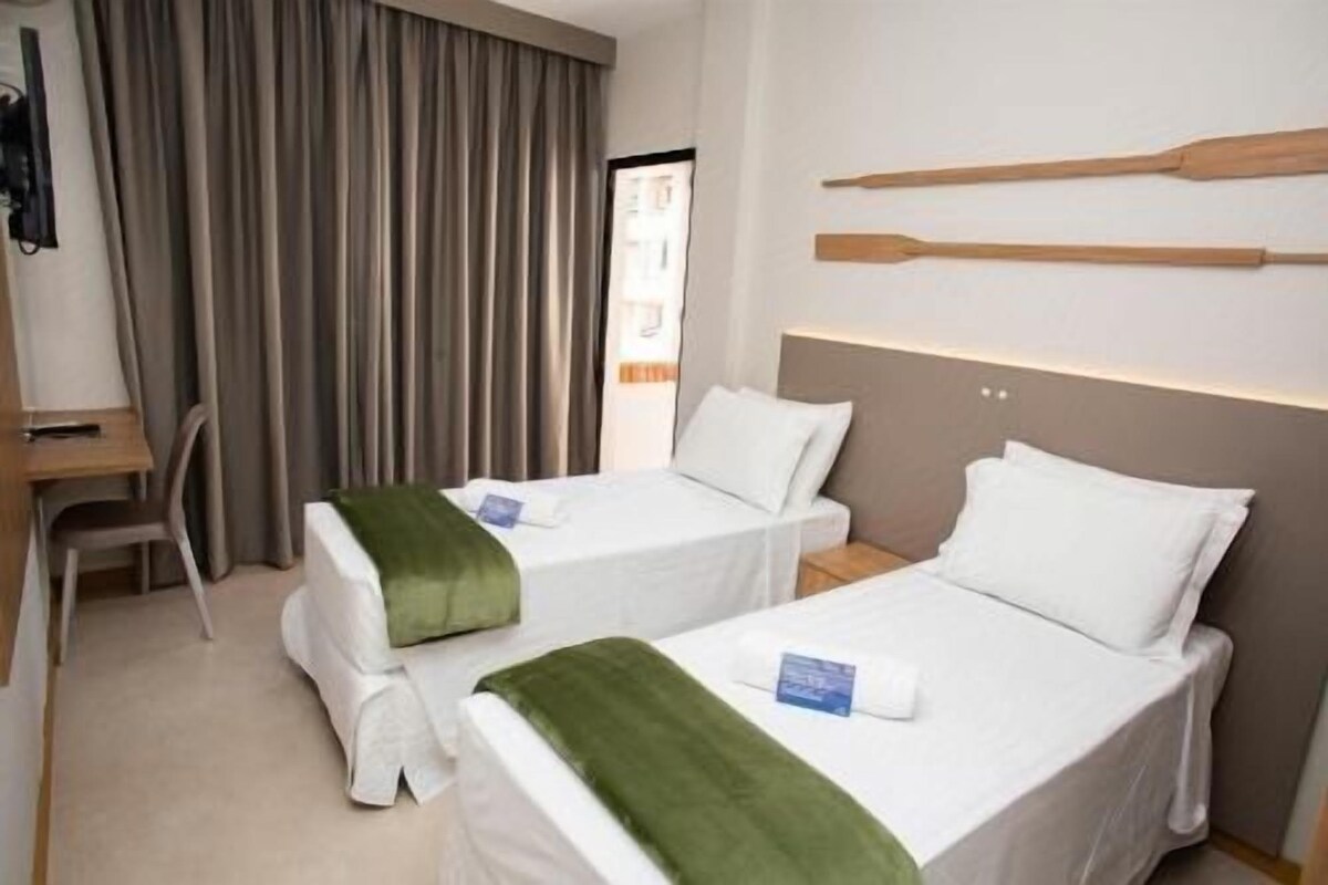 Una habitación de hotel con dos camas, un escritorio y una silla.