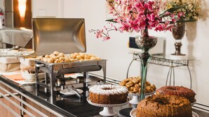 A buffet setup with various baked goods, including cakes and pastries, arranged on a counter. - Mar de Canasvieiras Hotel & Eventos (Florianópolis)