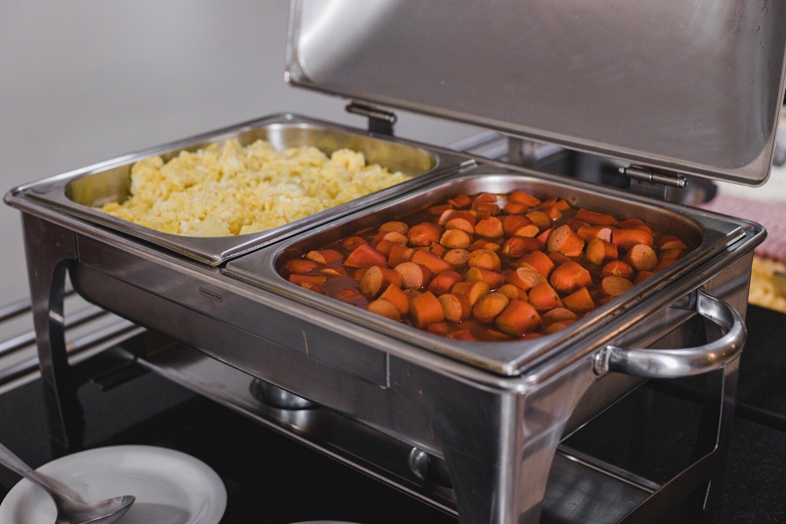 Una disposición de bufé con dos fuentes de acero inoxidable, una con arroz y la otra con zanahorias.