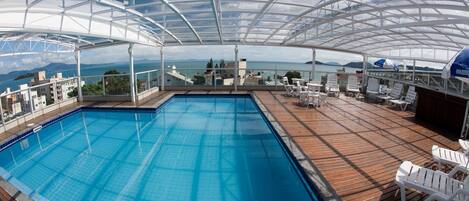 Una piscina techada con vistas al mar y a las montañas.