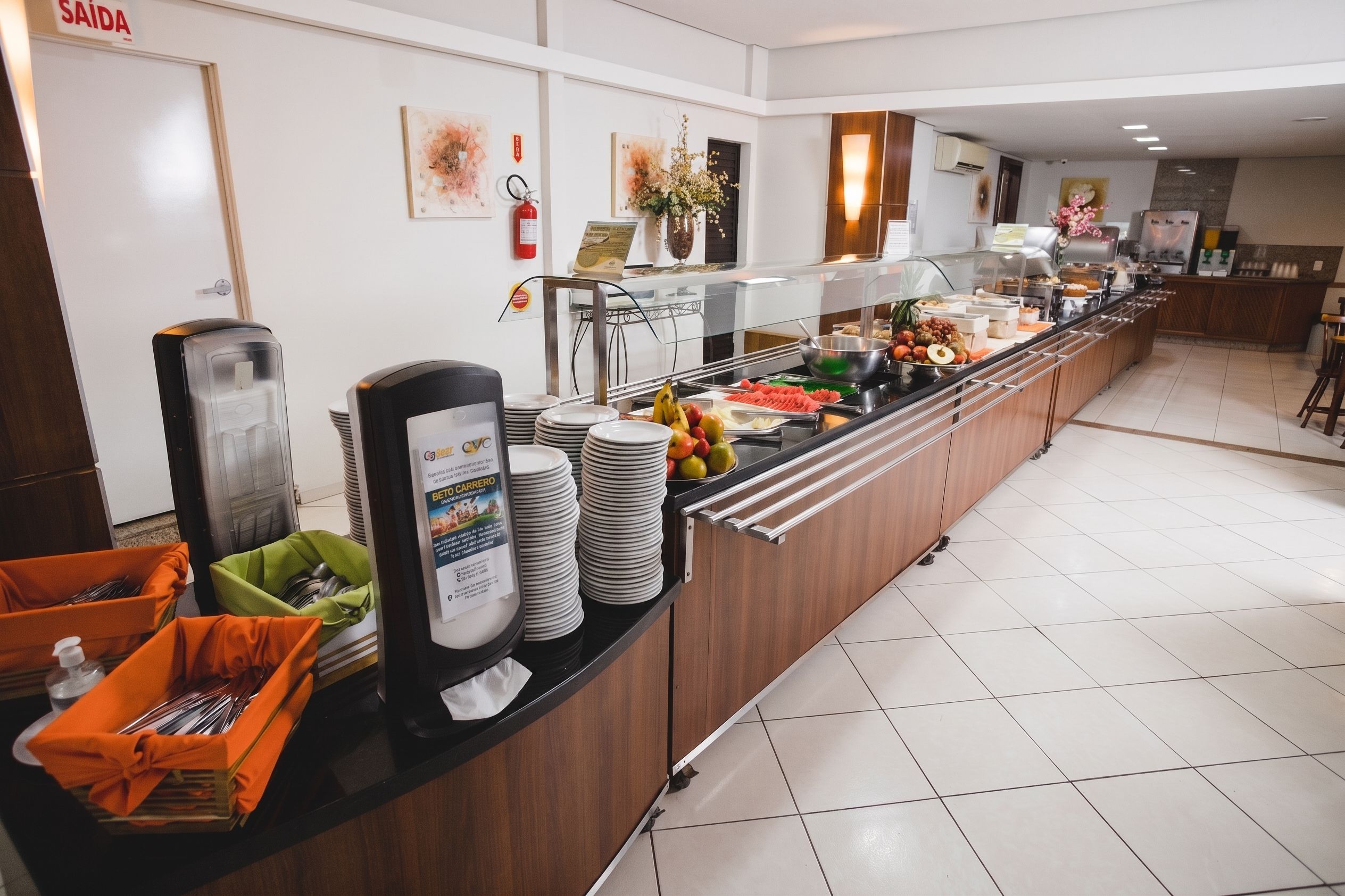 A buffet area with a variety of food items, a beverage dispenser, and a sign indicating the location.