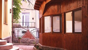 A wooden building with a stone staircase leading to a balcony. - Pension Brasovu' Vechi (Brasov)