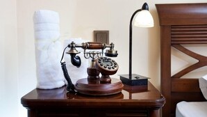 A wooden bedside table with an antique rotary phone and a lamp. - Pension Brasovu' Vechi (Brasov)