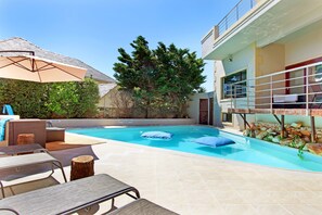 Utomhuspool, parasoller och solstolar