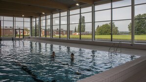 Una piscina interior con vistas despejadas a los edificios y la vegetación circundantes.