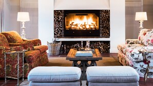 A cozy living room with a fireplace, two sofas, a coffee table, and two lamps. - Galenia Estate (Montagu)