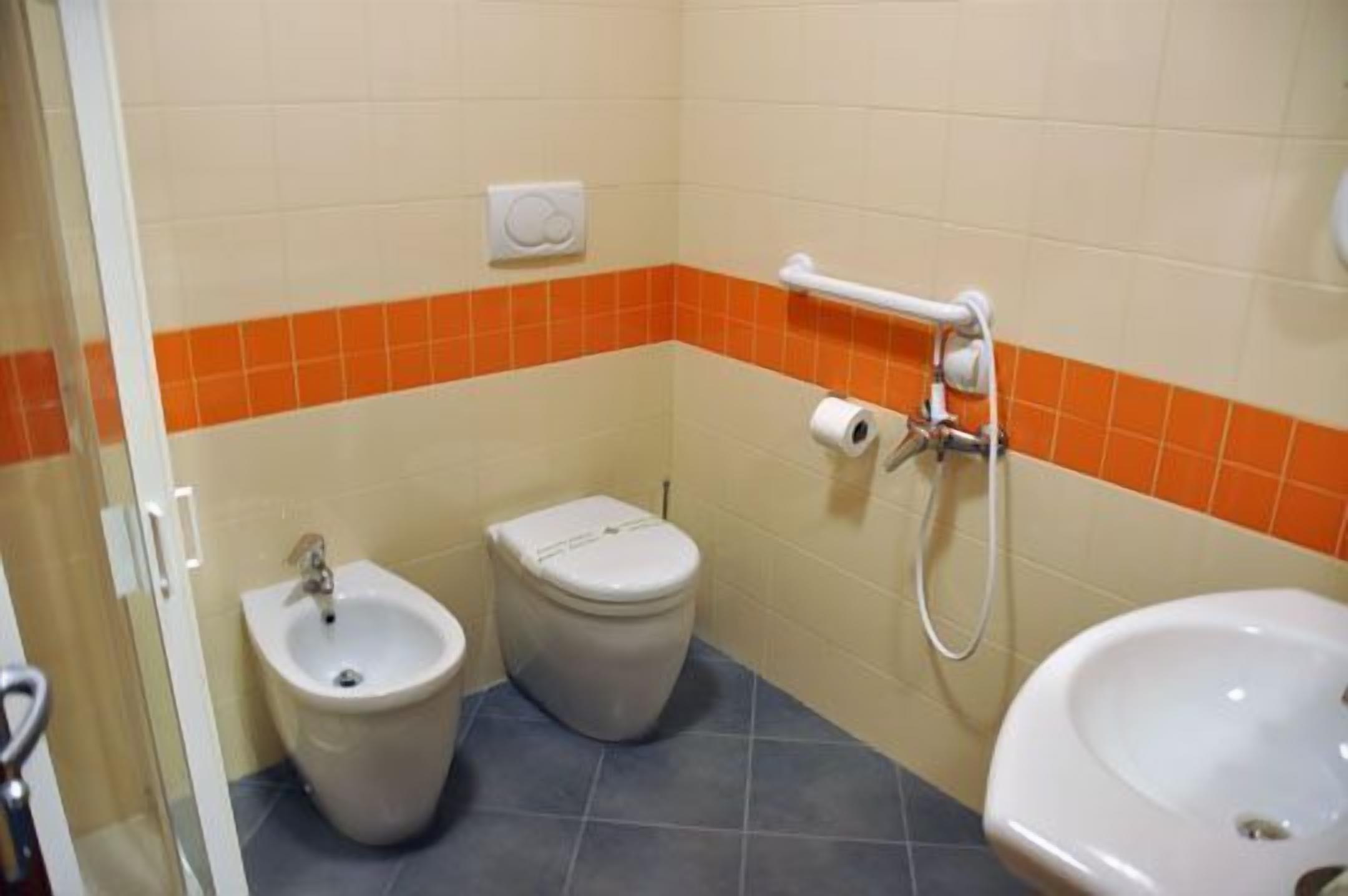 Un baño con bidé, inodoro y lavamanos.
