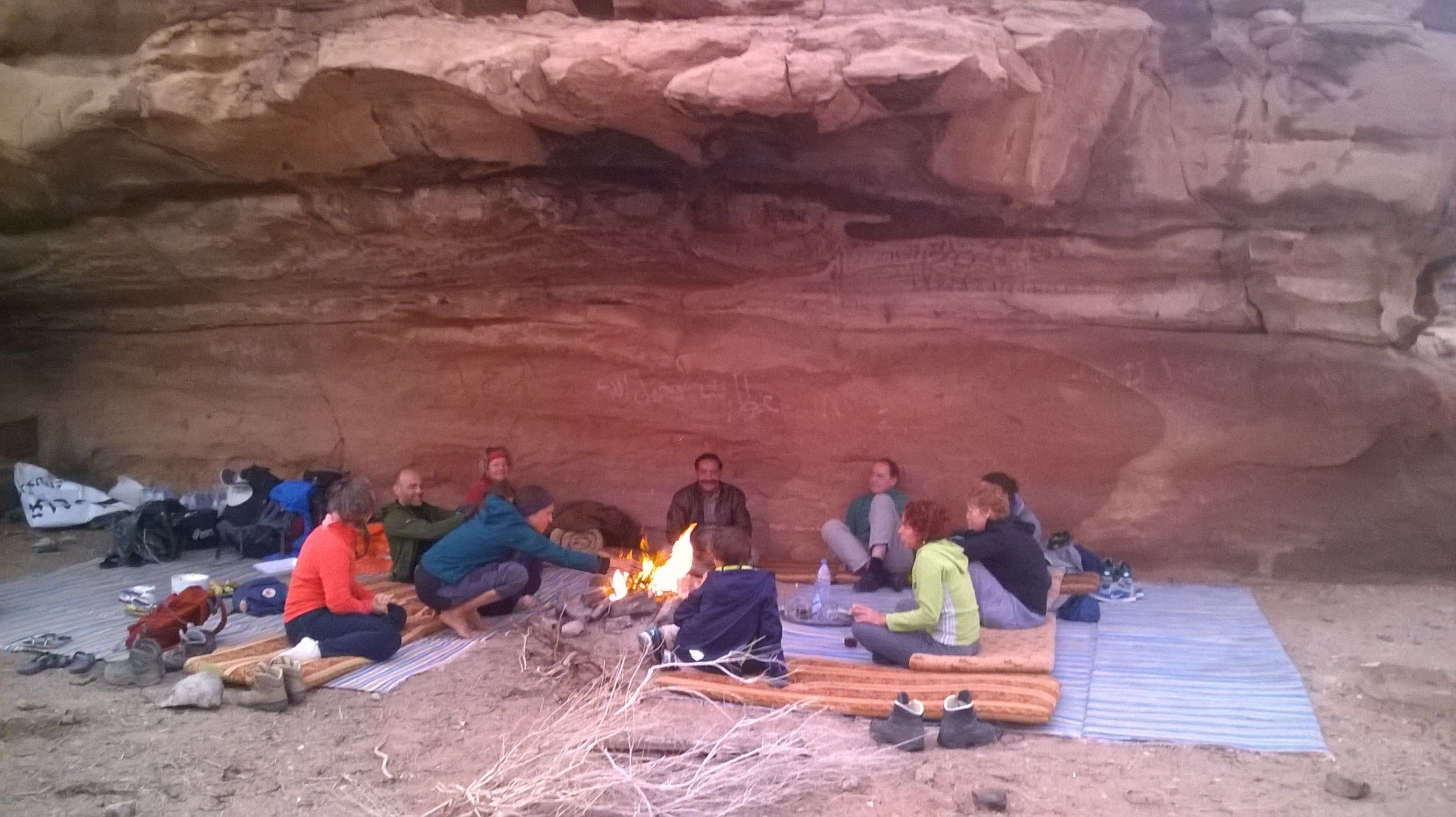 Un grupo de personas sentadas alrededor de una fogata en una cueva.