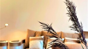 Een woonkamer met een bank, bijzettafeltje en decoratieve planten.