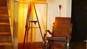 A staircase with a wooden handrail and a lamp post. - Casa Kalfu (Puerto Varas)