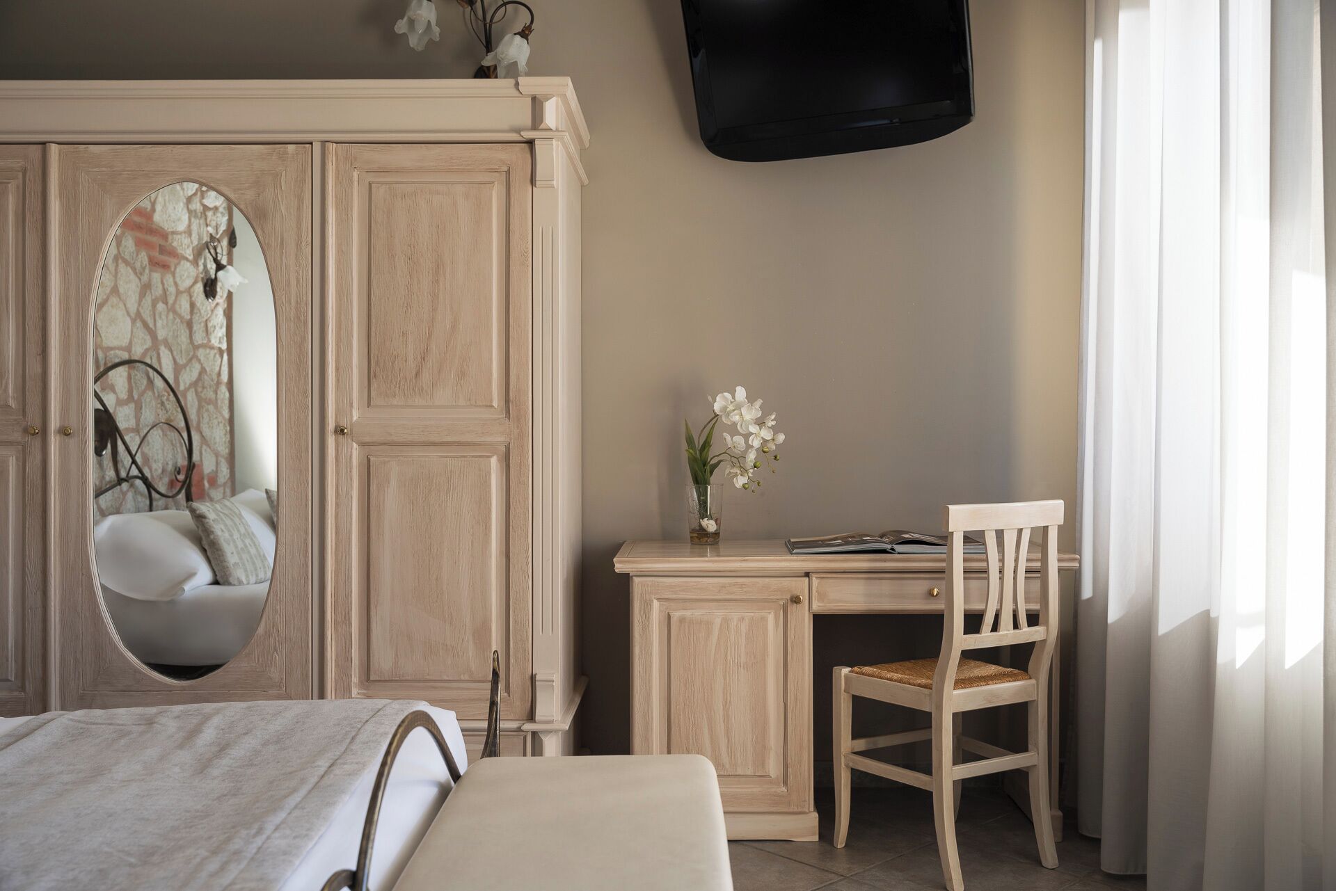 A bedroom with a bed, a desk, a chair, and a wardrobe.