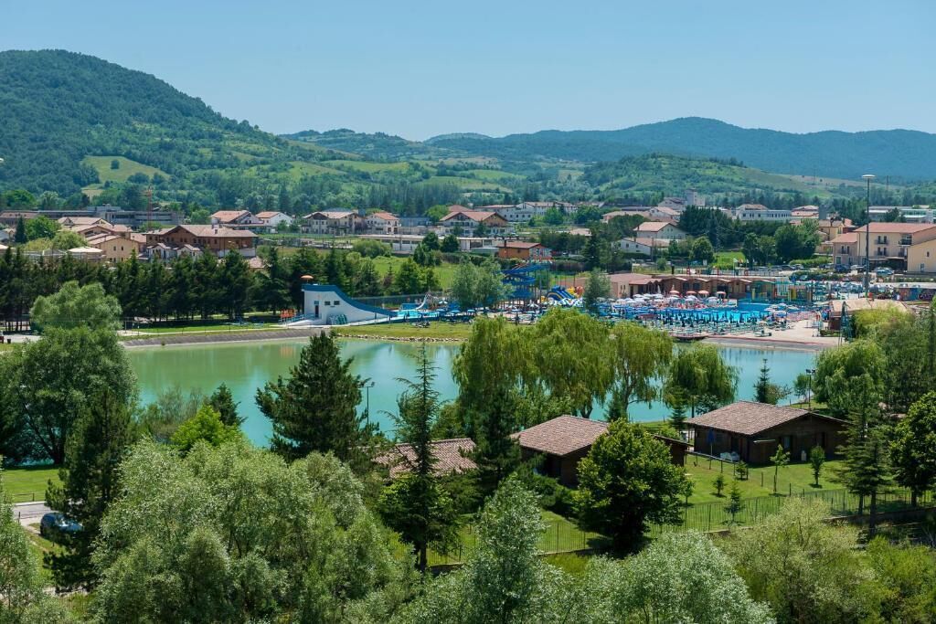 Un paese sul lago con piscina e un piccolo edificio in primo piano.