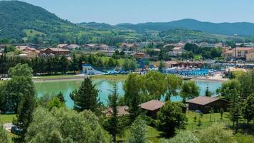 Un paese sul lago con piscina e un piccolo edificio in primo piano.