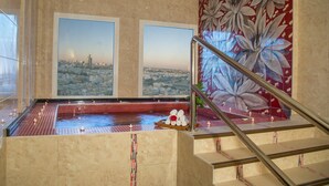 A spa area with a cityscape view, a tiled floor, and a staircase with a railing. - Rayan Hotel Sharjah (Sharjah)