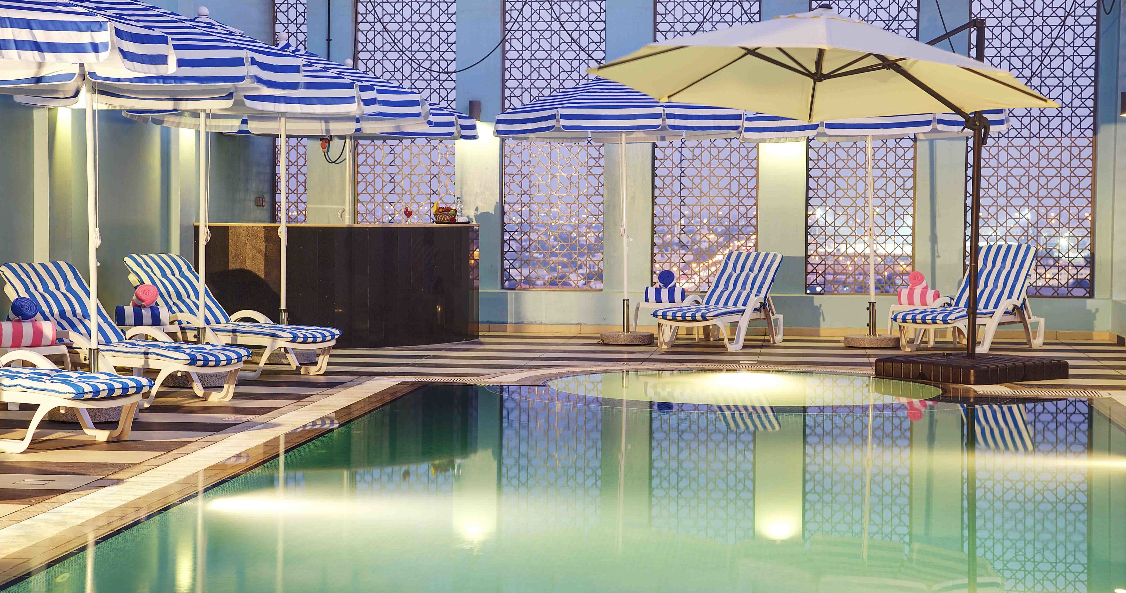 Una piscina al aire libre, sillones reclinables de piscina