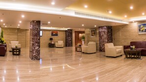 A spacious lobby with marble flooring, multiple seating areas, and a modern design. - Rayan Hotel Sharjah (Sharjah)