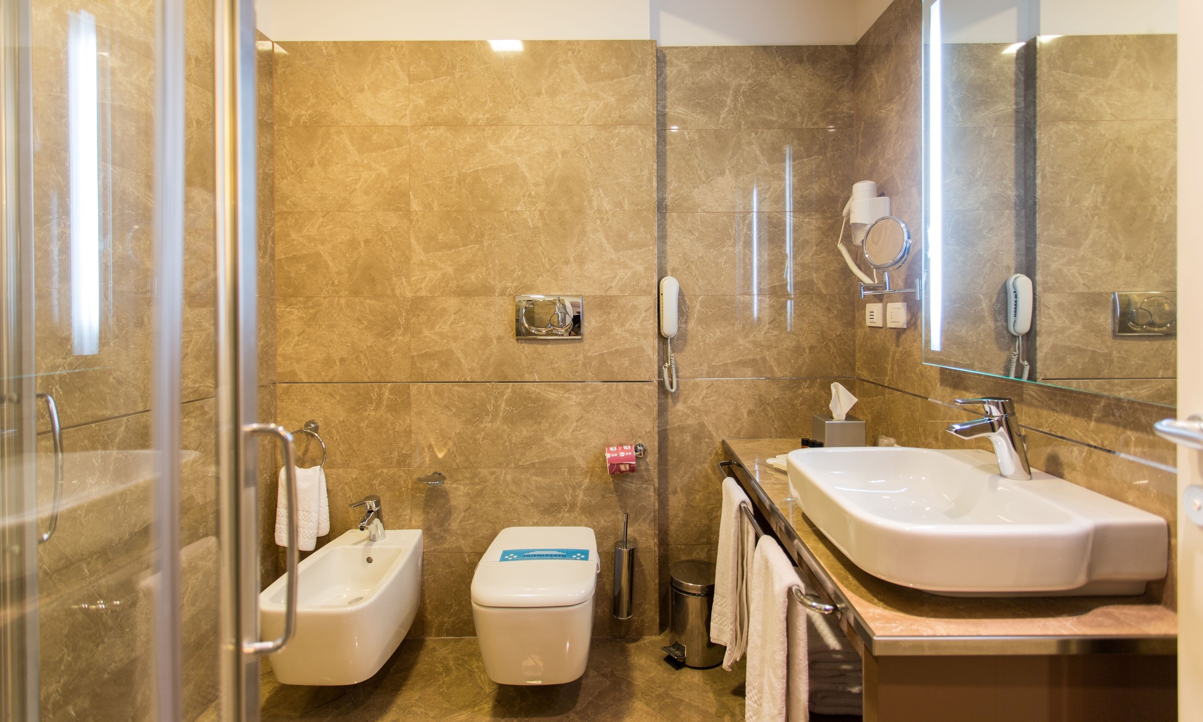 A modern bathroom with a bidet, toilet, and sink.