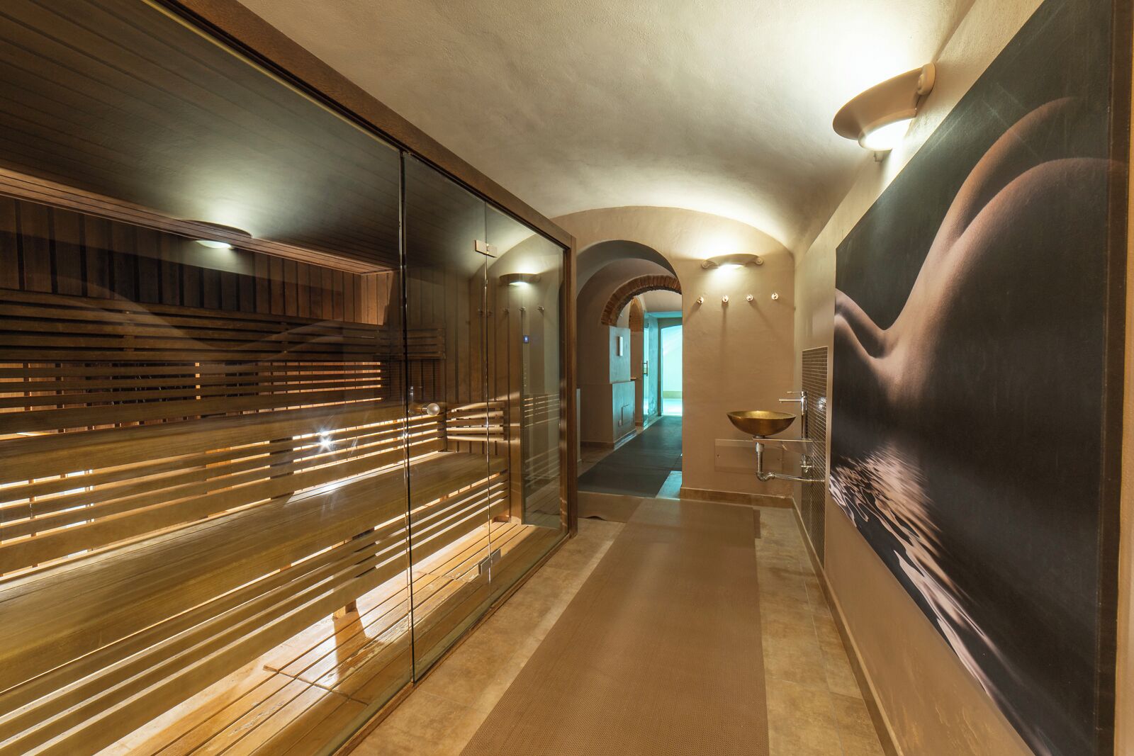 A modern hallway with a glass wall, wooden slats, and a large abstract painting.