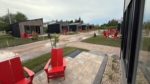 Un edificio moderno con varias unidades, asientos al aire libre y un patio empedrado.