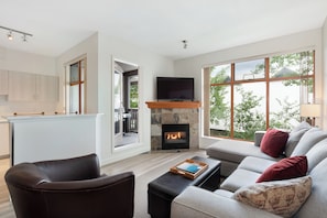 A modern living room with a fireplace, a sofa, a coffee table, and a TV. - Northstar by Whiski Jack (Whistler)