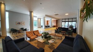 A spacious lobby with a seating area, a bar, and a view of the outdoor patio. - Transamerica Araraquara (Araraquara)