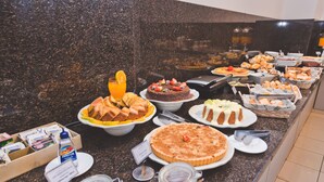A buffet with various food items including cakes, pastries, and a variety of breads. - Transamerica Araraquara (Araraquara)