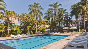 A swimming pool with lounge chairs and palm trees. - Transamerica Araraquara (Araraquara)