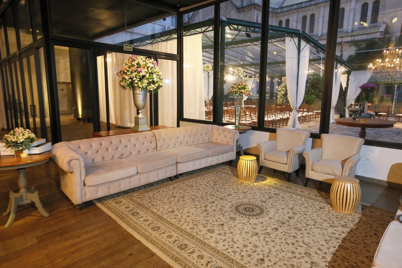 A modern interior with a large sofa, armchairs, and a patterned rug.