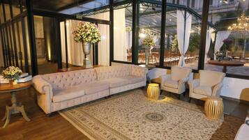 A modern interior with a large sofa, armchairs, and a patterned rug.
