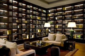 A library with bookshelves, two lamps, and a sofa. - InterContinental Foshan by IHG (Foshan)