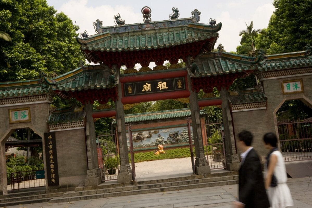 A traditional Chinese gate with ornate decorations and a sign.
