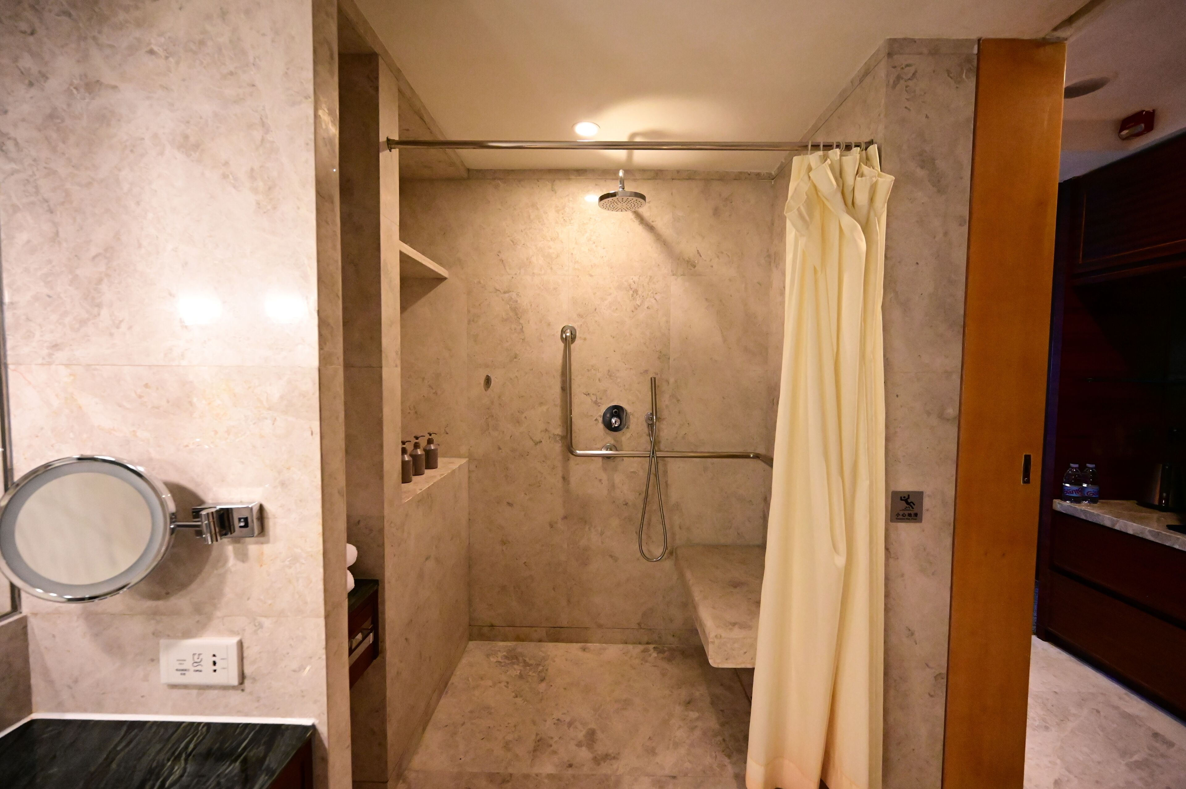 Een moderne badkamer met een douche, toilet, wastafel en spiegel.