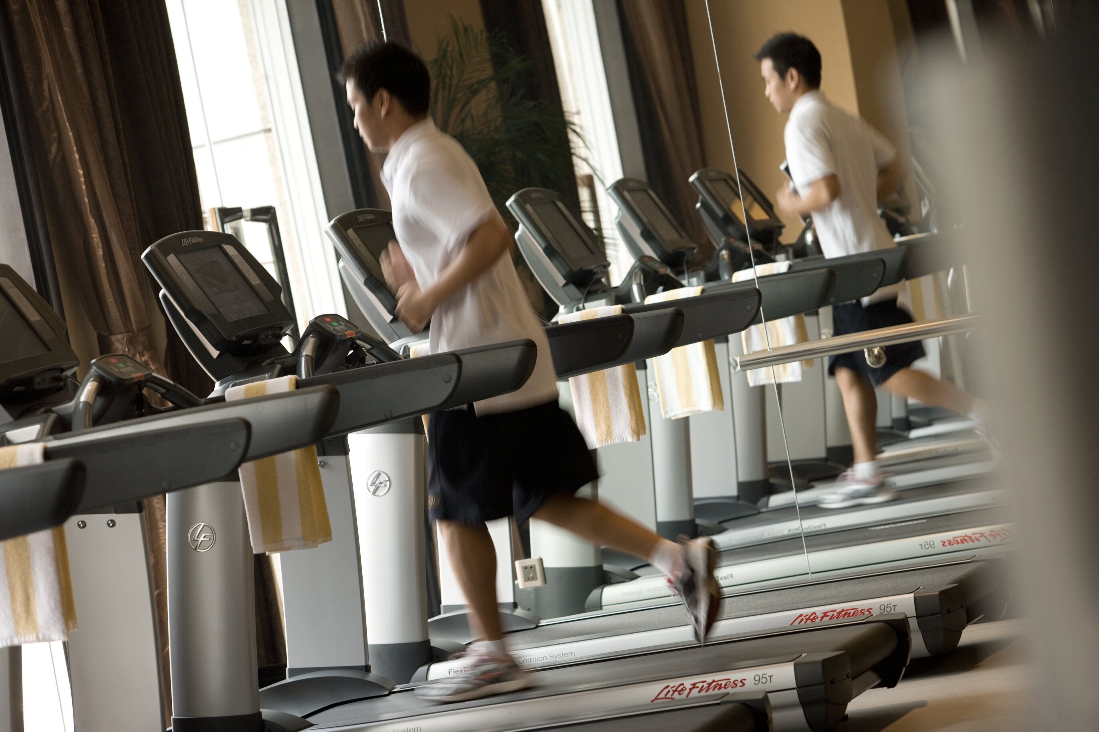 Un gimnasio con cintas de correr y equipo de ejercicio.