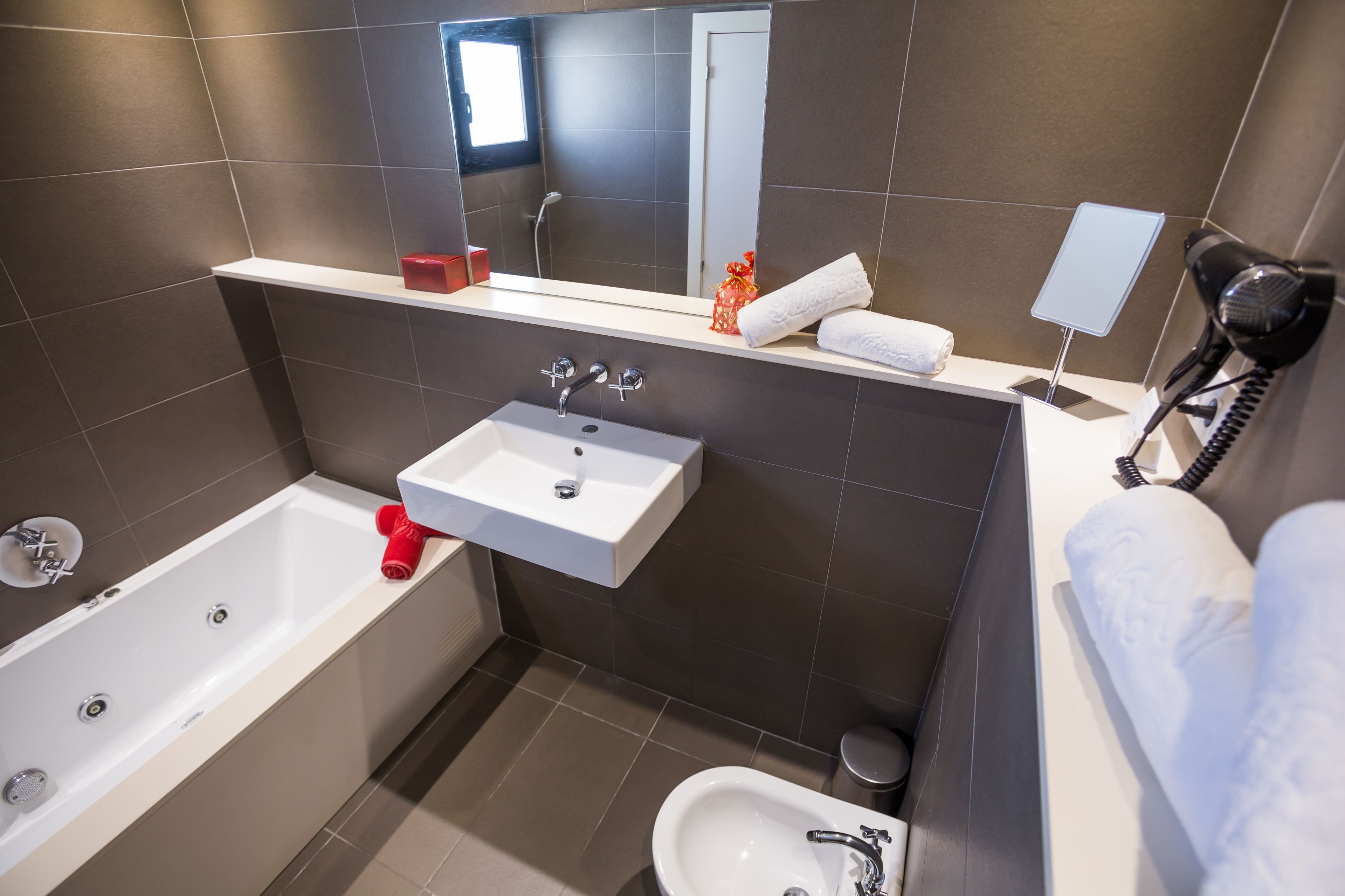 A modern bathroom with a bathtub, a sink, and a bidet.